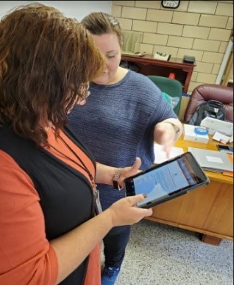 Two women looking at a mobile device tablet